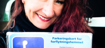 Marianne viser frem parkeringkort for forflytningshemmede