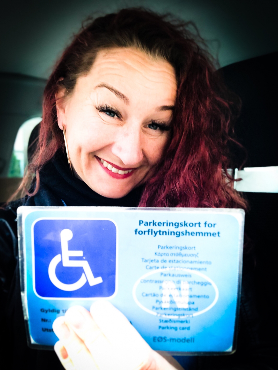 Marianne viser frem parkeringkort for forflytningshemmede